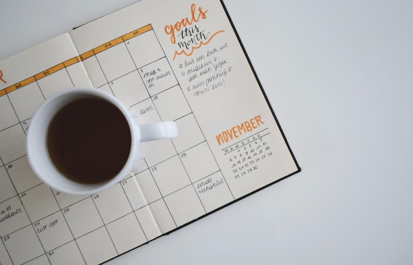 A hand-written planner page beside a cup of coffee.