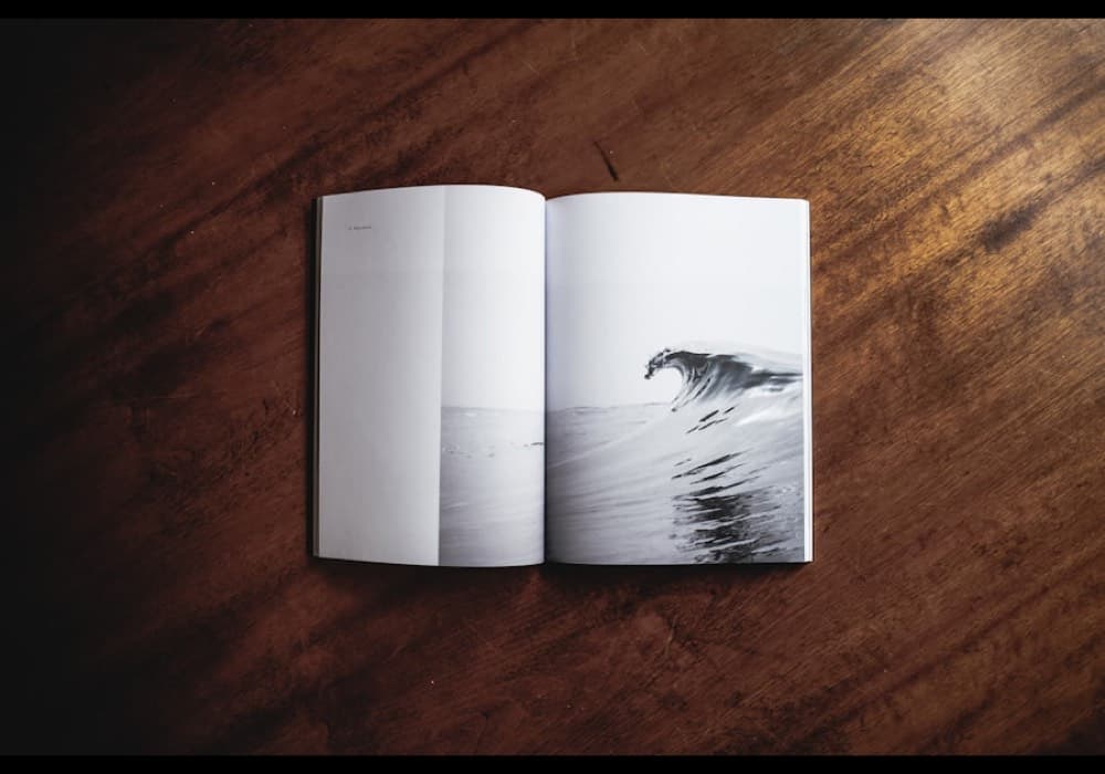 An open magazine lying on a dark wooden table.