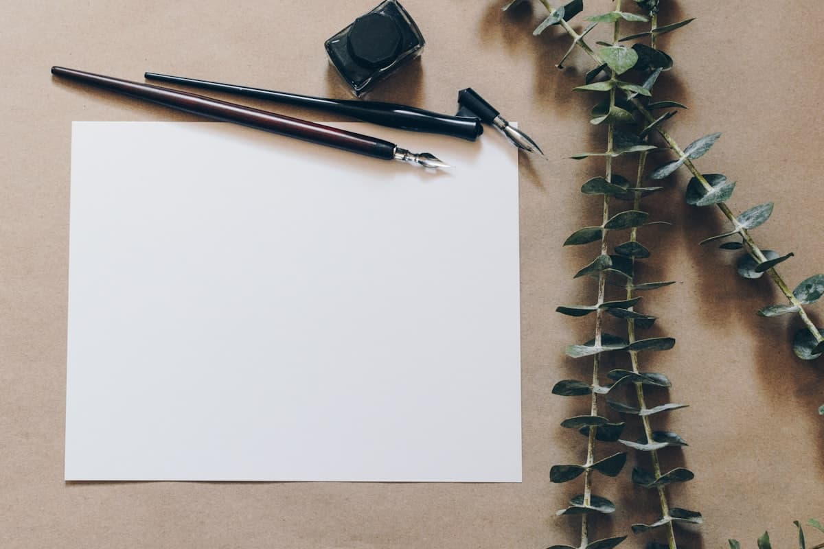 Blank paper and pencils arranged on a pale surface.